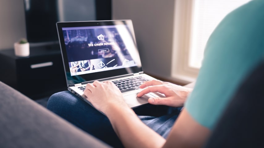 A man working on a laptop on his lap.