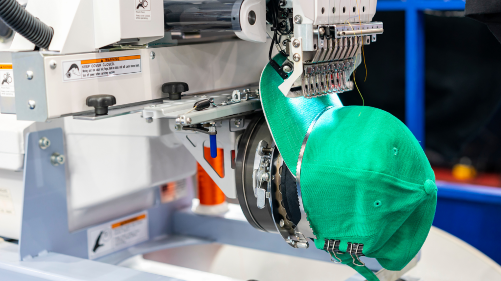 A green hat is being placed onto a machine, showcasing a unique interaction between the accessory and technology.