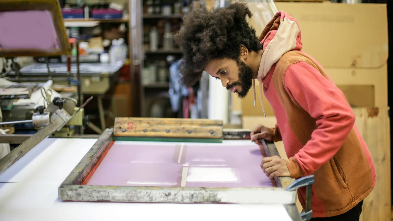 A man checking if everything is correct before screen printing on a t-shirt.