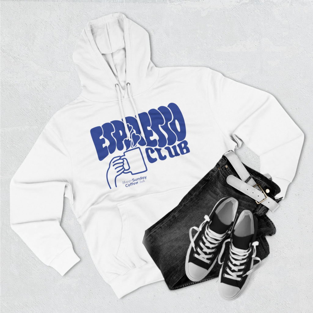 A custom white hoodie with an “Espresso Club” print, with a pair of jeans and shoes next to it.